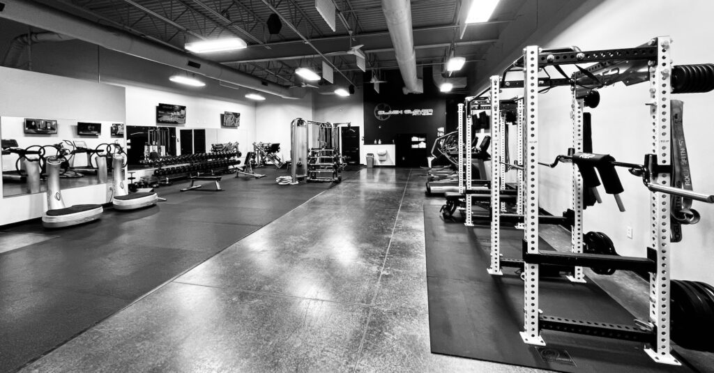 Fitness center interior showcasing workout equipment, including weight racks and cardio machines, emphasizing health and exercise in a gym environment.